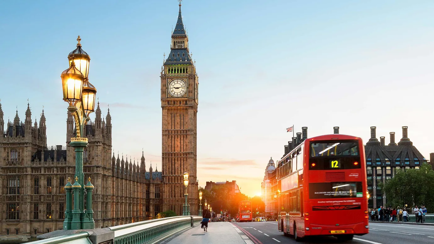 A sunset view of a clock tower and bridge in London, England