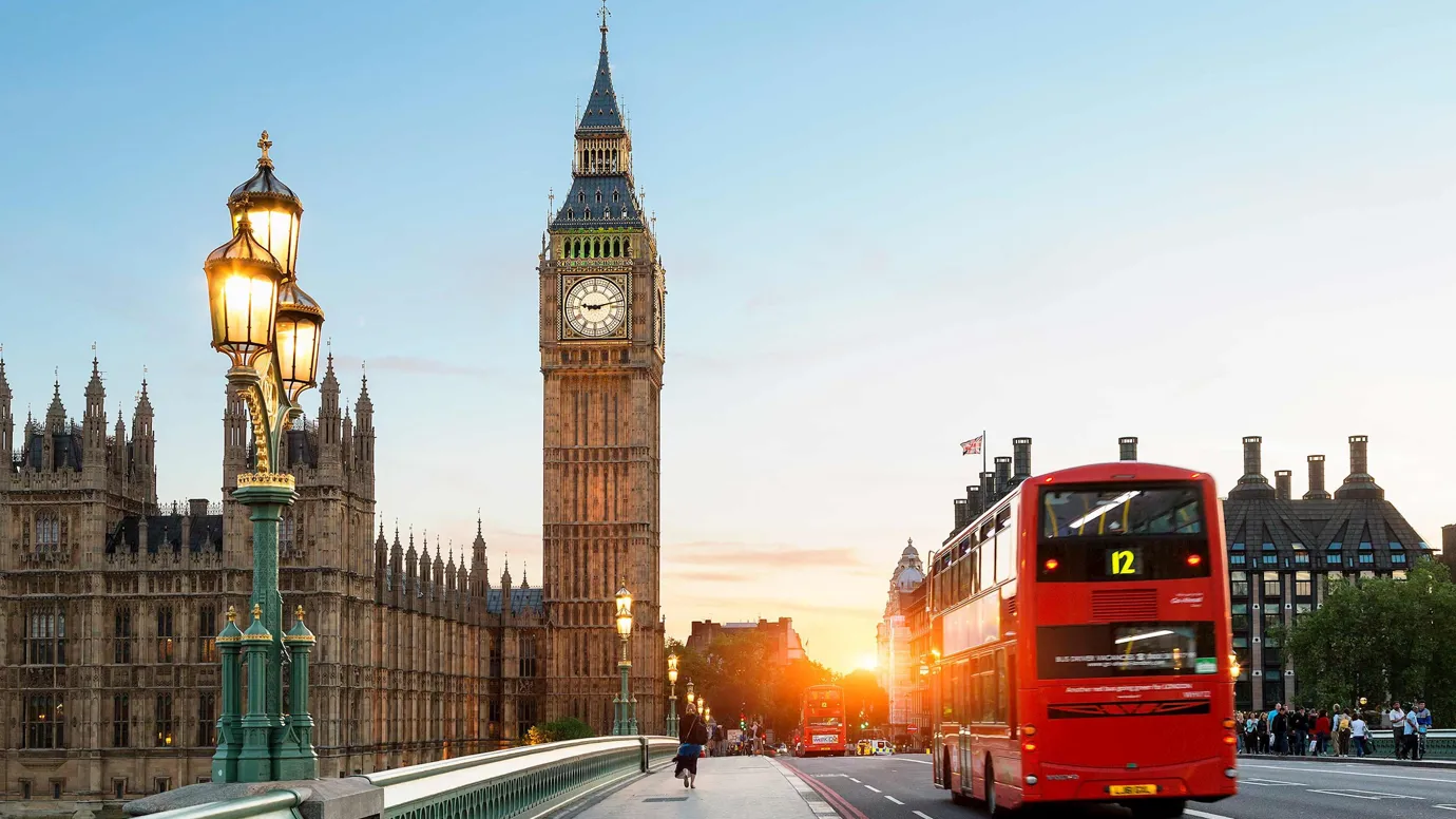 A sunset view of a clock tower and bridge in London, England