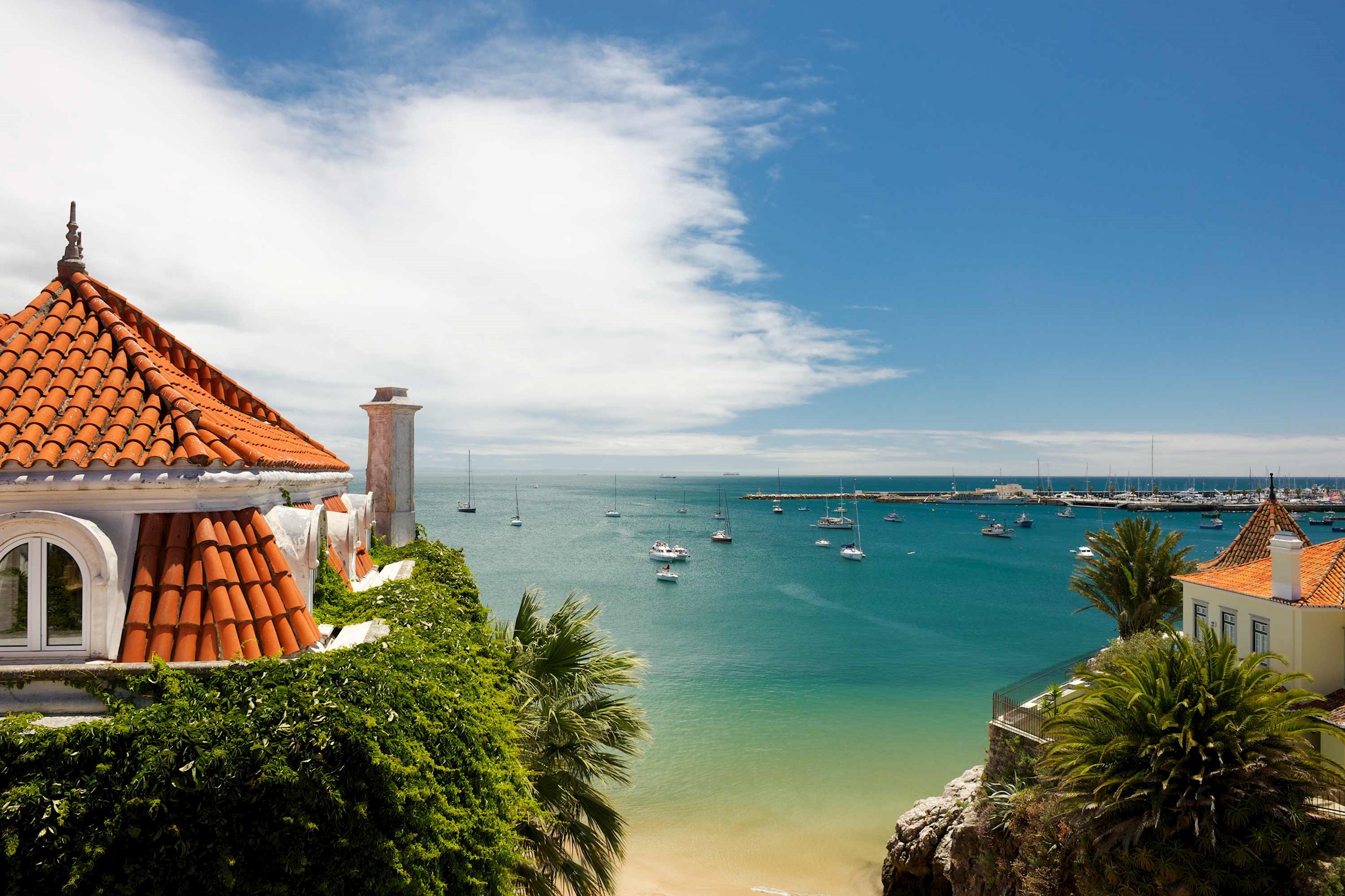 Scenic view of Cascais bay with sailboats and terracotta rooftops in Portugal