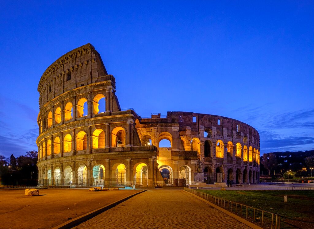 medium-view-of-coliseum-against-blue-sky-at-night-1323561047.jpg