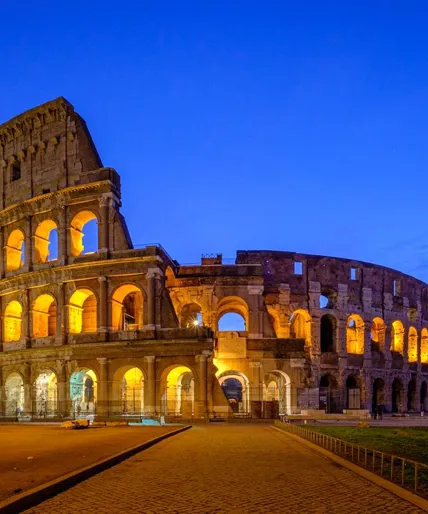 medium-view-of-coliseum-against-blue-sky-at-night-1323561047.jpg