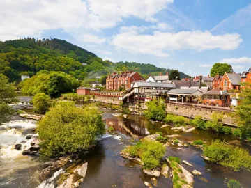 Riverside town with historic buildings and green hills in Llangollen, Wales
