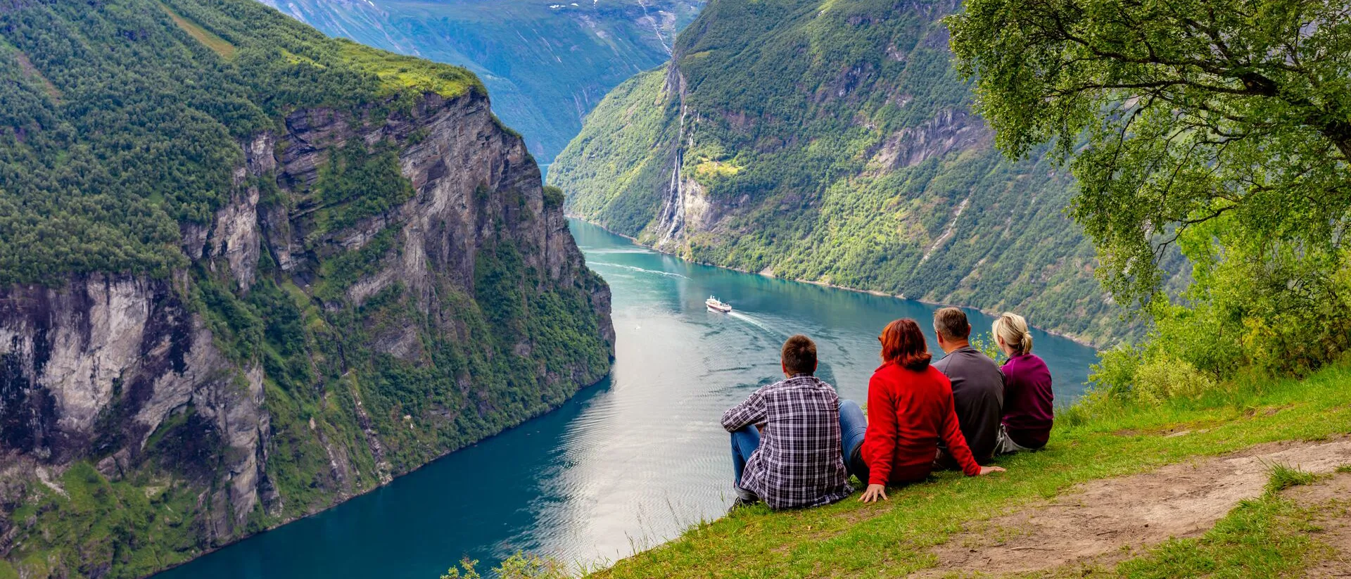 Group of friends watching boat go along The Geirangerfjord Norway