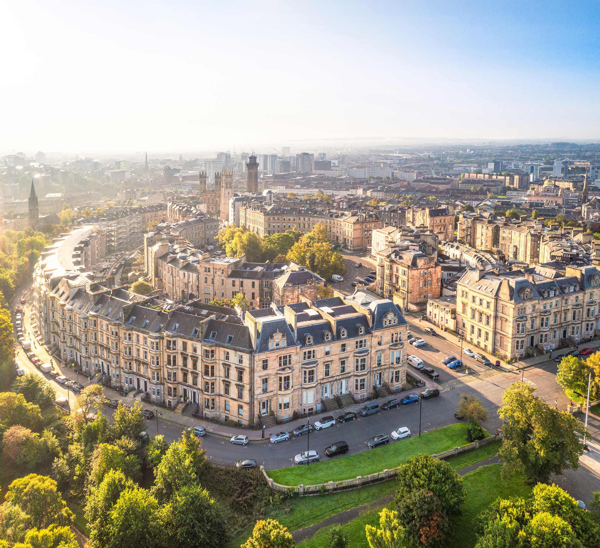 Aerial view of curved street lined with historic stone buildings in Glasgow, Scotland