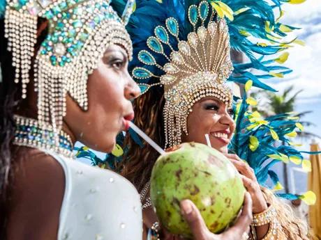 Carnival dancers drinking cocktails out of coconuts in Rio de Janeiro, Brazil