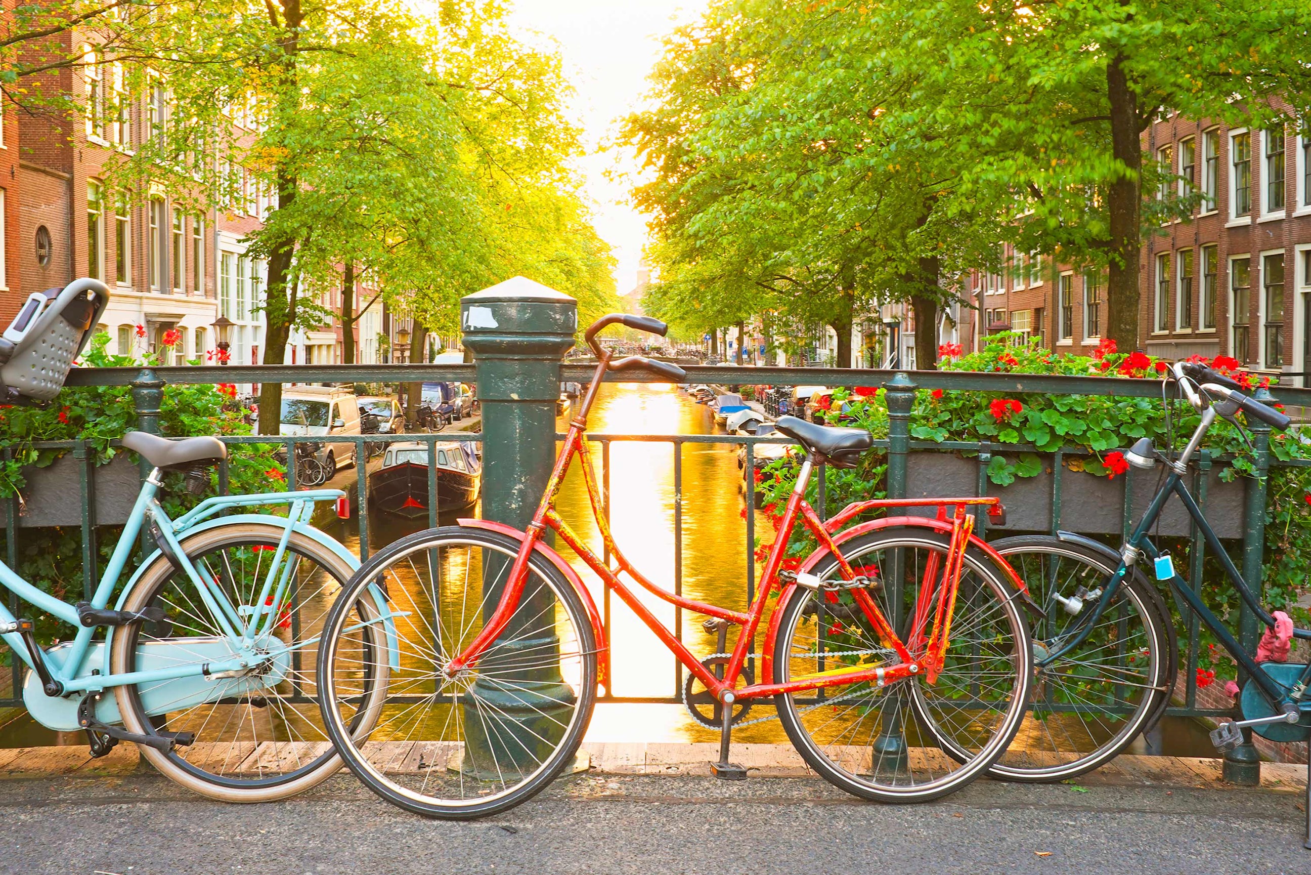Row of colourful bicycles on a bridge above canal in Amsterdam, Netherlands