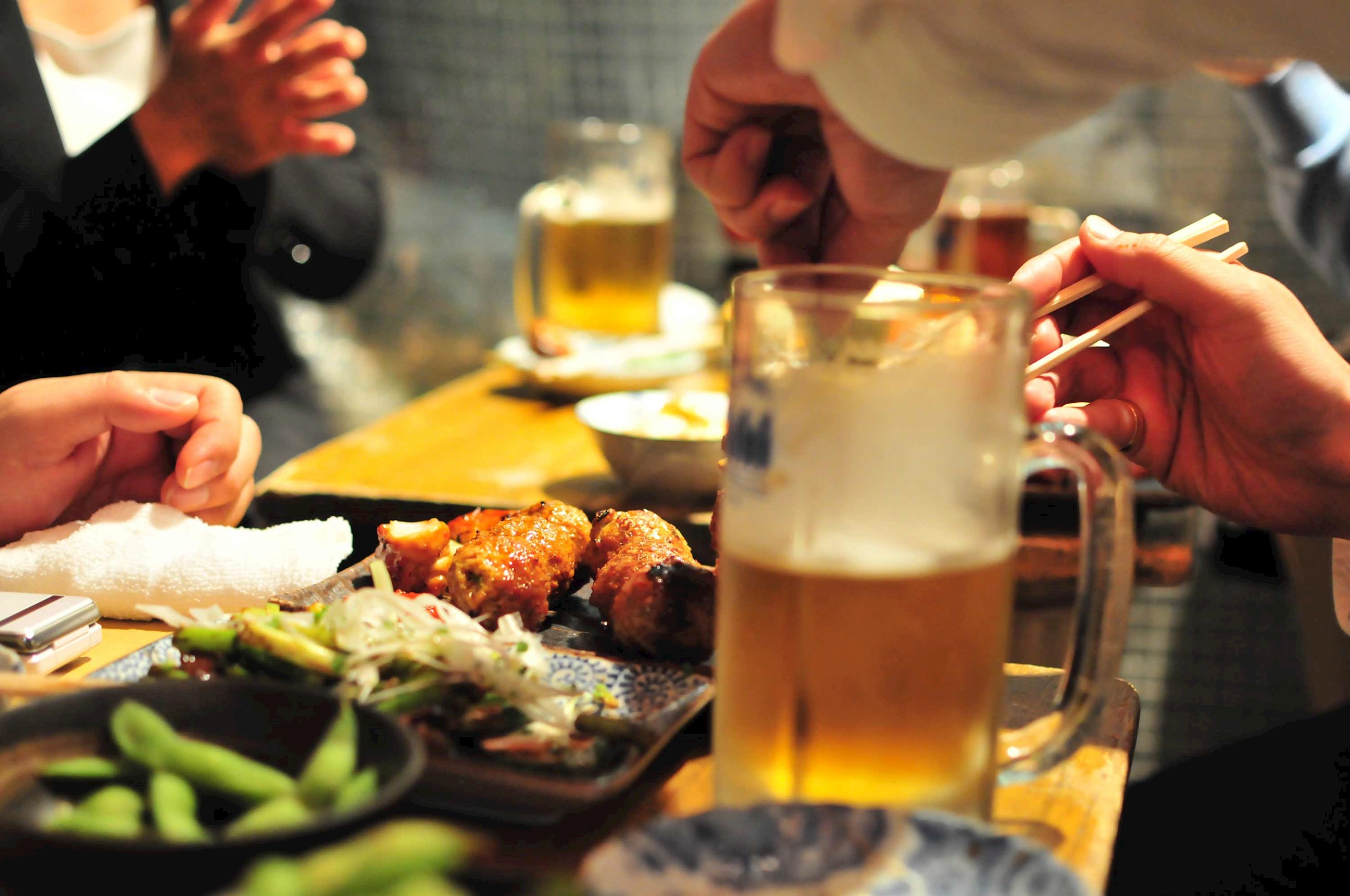 Table full of dishes for tourists experiencing Izakaya Dining in Kyoto, Japan