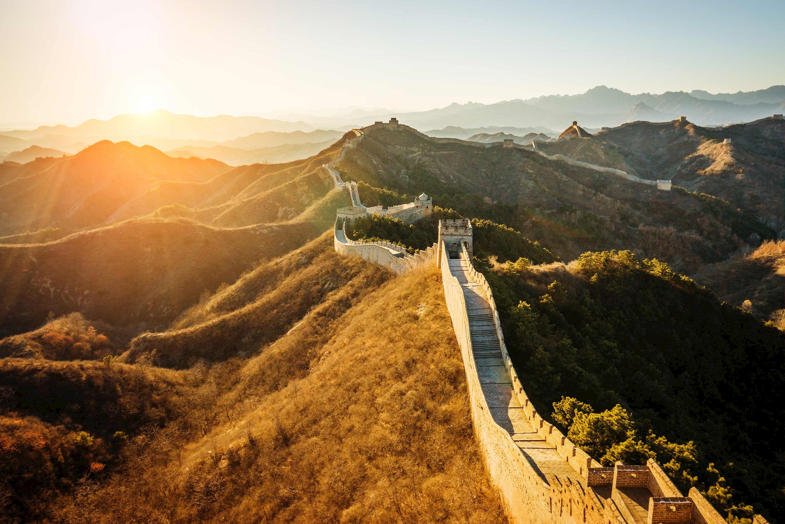 Great Wall of China winding over mountain ridges at sunrise