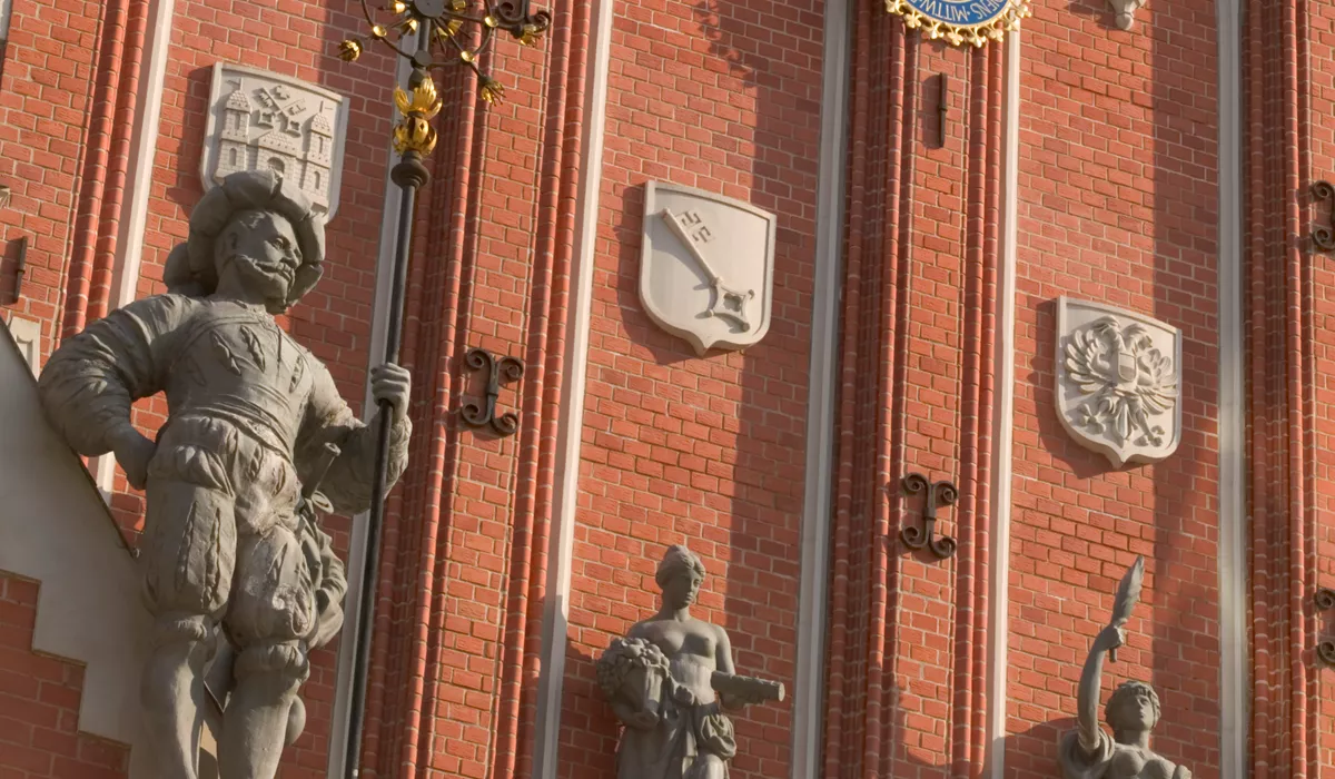 House Of The Black Heads, A building with a clock and statues on the side of it in Riga, Latvia