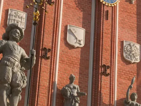House Of The Black Heads, A building with a clock and statues on the side of it in Riga, Latvia