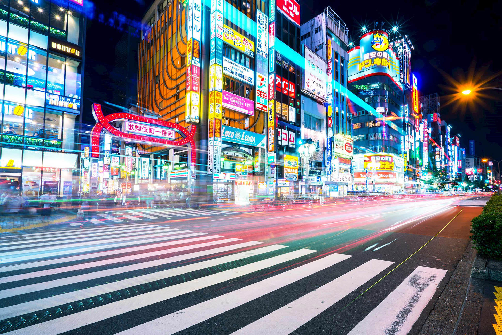 Night view of Shinjuku street with neon lights and busy crosswalk in Japan