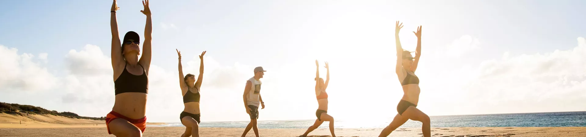 Friends doing yoga in the sand