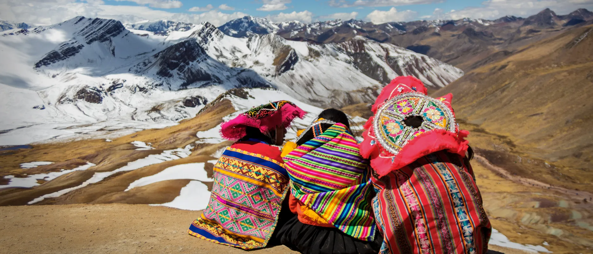 Women in traditional clothing looking at the Peruvian Mountians in Peru, South America
