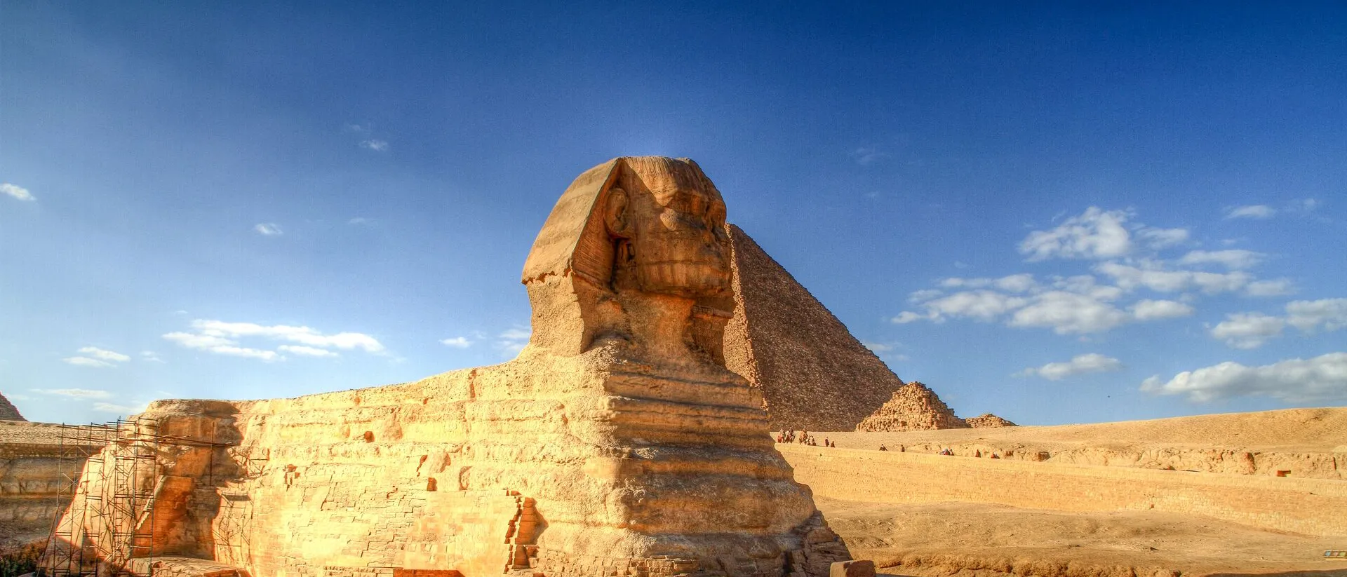 The Great Sphinx of Giza with Pyramids in the background on a sunny day, Egypt