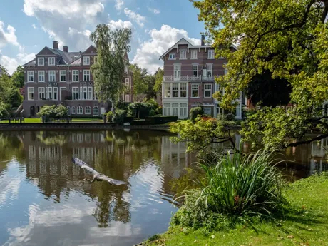 A lake surrounded by tall buildings in Vondel Park Holland Amsterdam