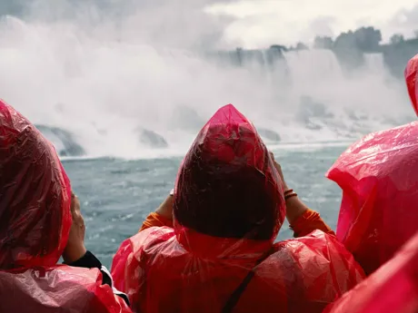People in red ponchos looking at Niagara Falls in Canada