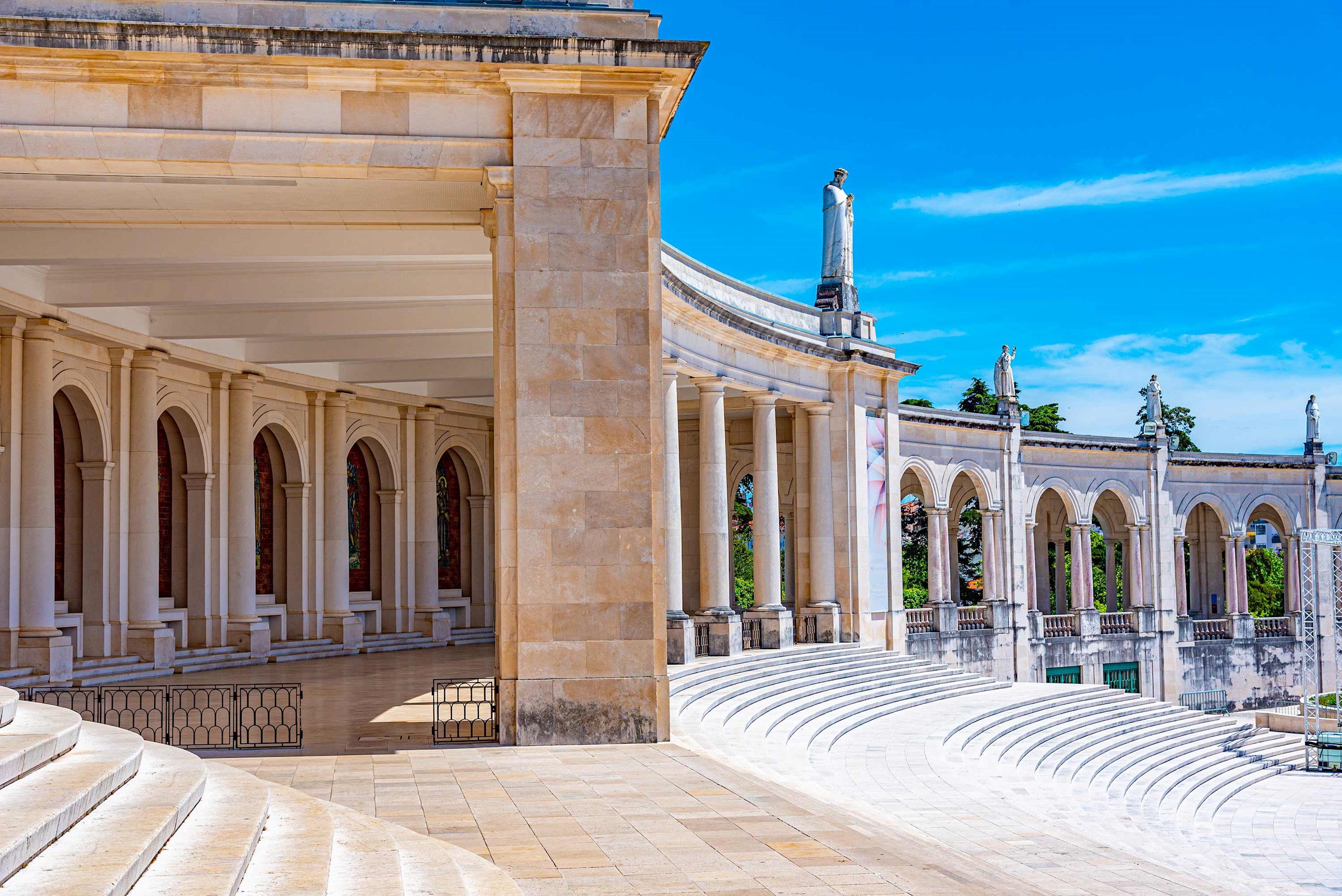 Curved arches and steps under bright blue sky in Fatima, Portugal