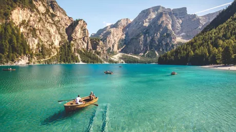 Small boat on a lake surrounded by mountains in Italy