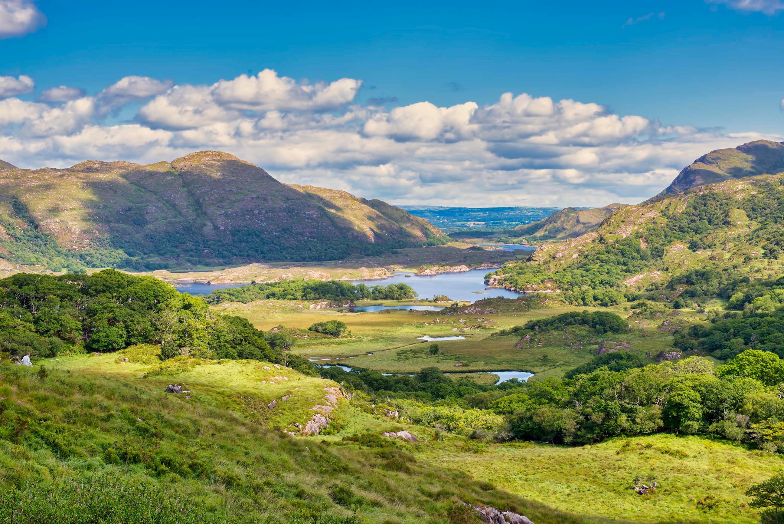 A green valley with lakes surrounded by mountains in The Ring of Kerry Ireland
