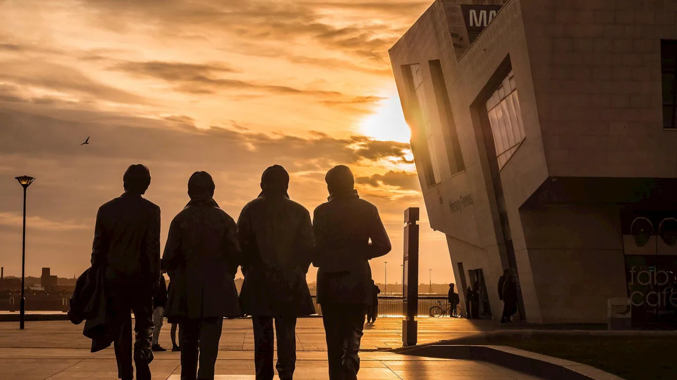 A sunset view of The Beatles Statue in Liverpool, England