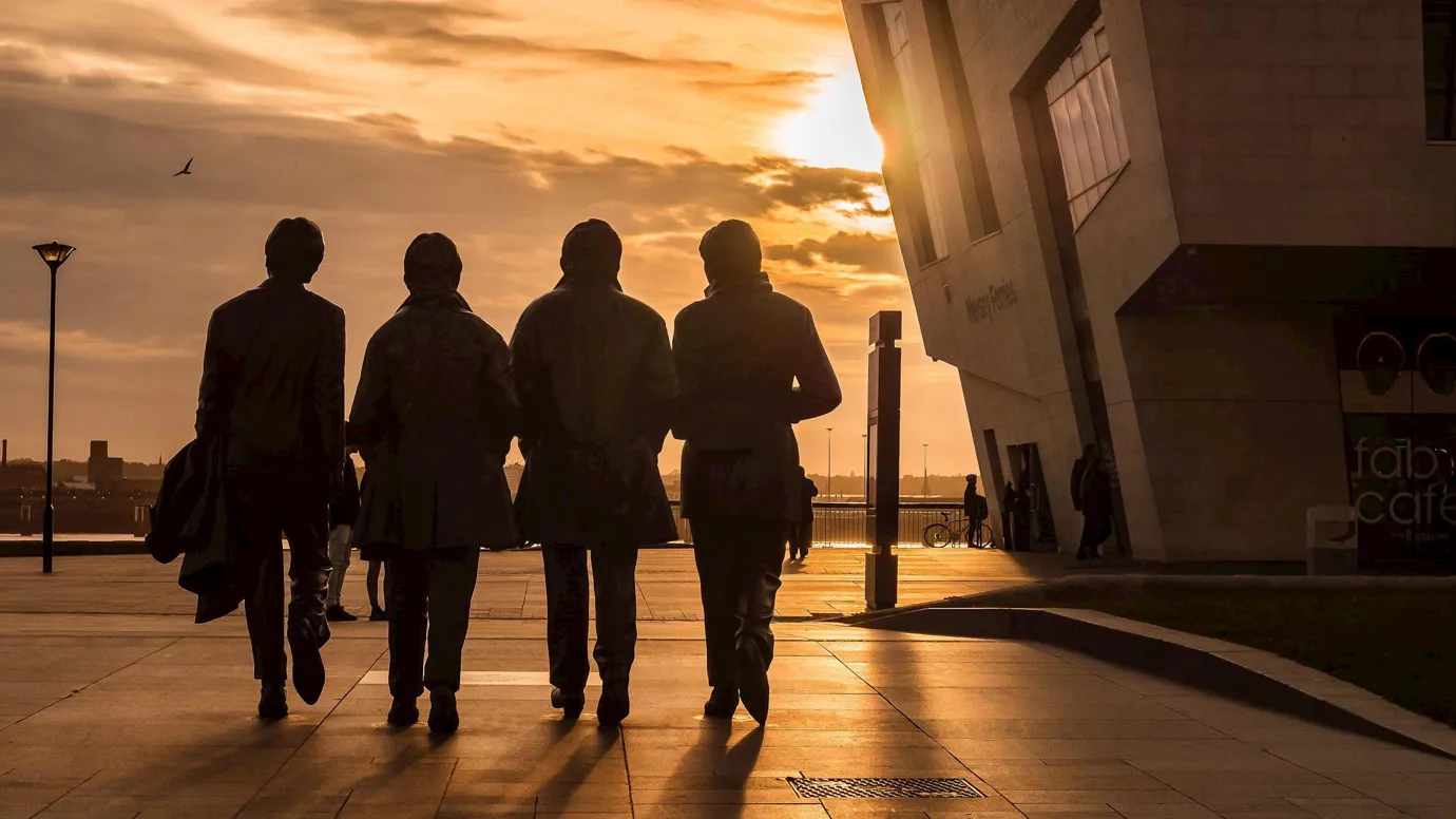 A sunset view of The Beatles Statue in Liverpool, England