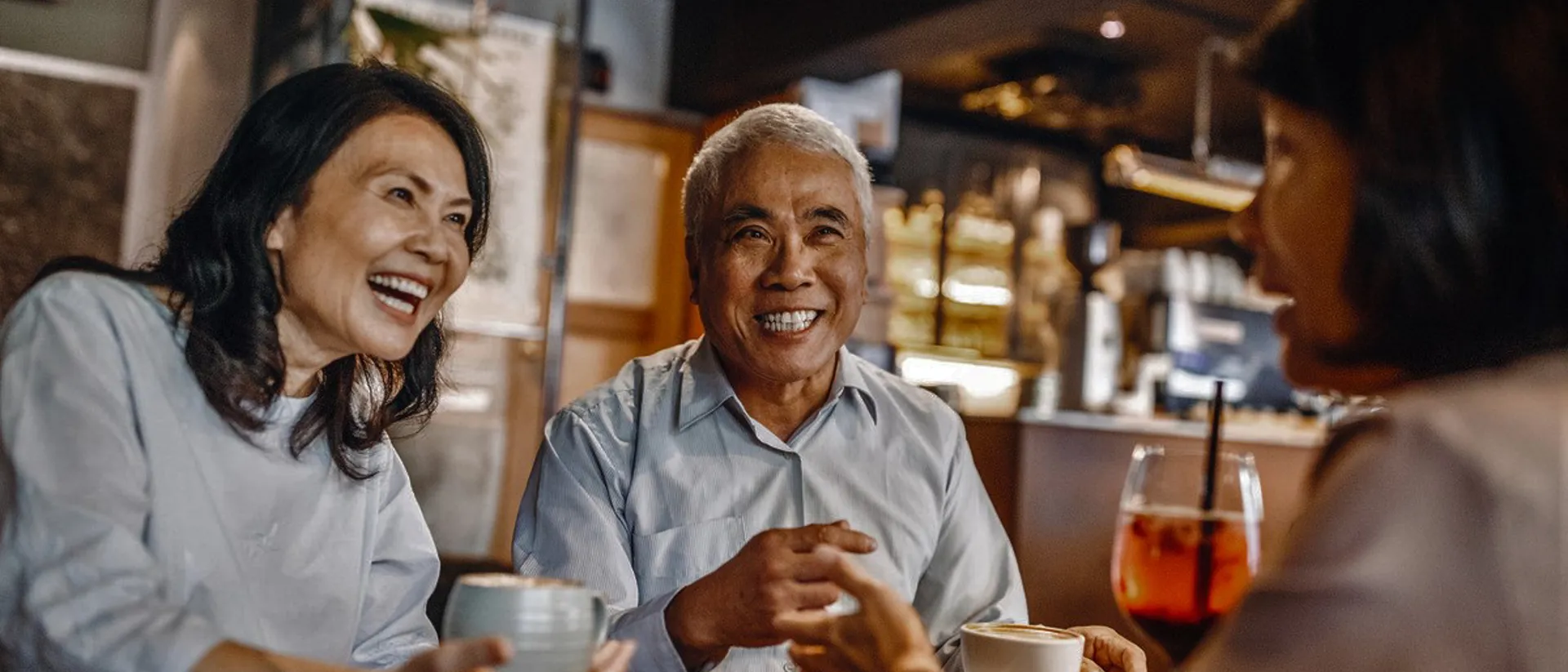 Travellers sitting in a coffee shop drinking and laughing