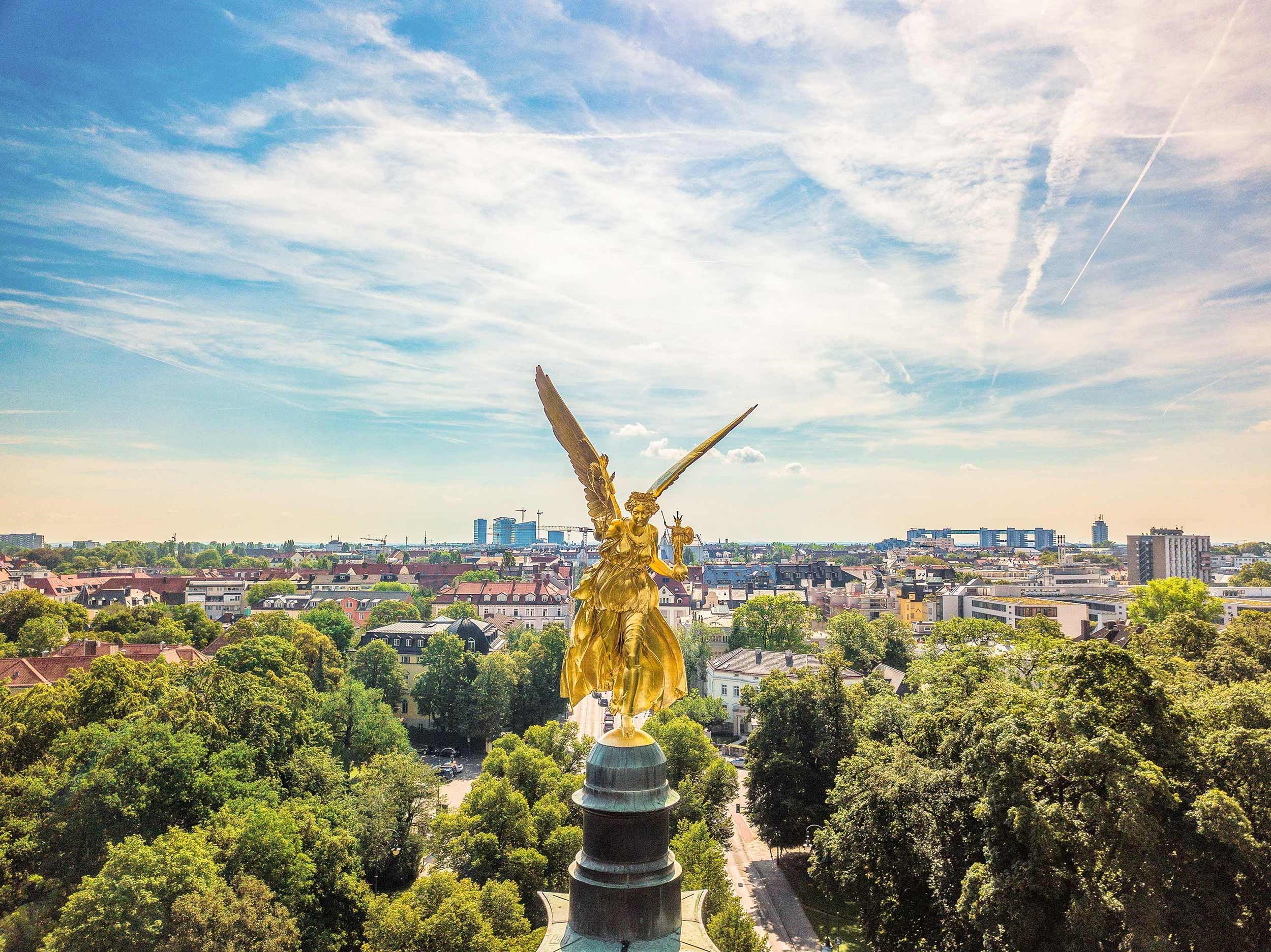 A scenic view of a golden statue on a sunny day in Munich, Germany