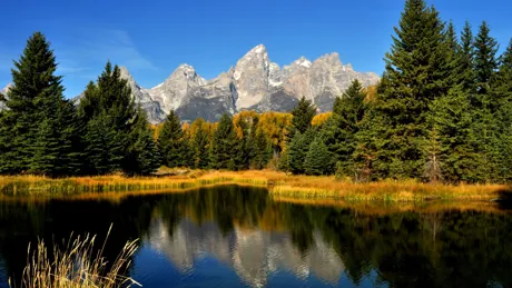 The Grand Tetons reflecting in a lake in Wyoming, USA at Fall