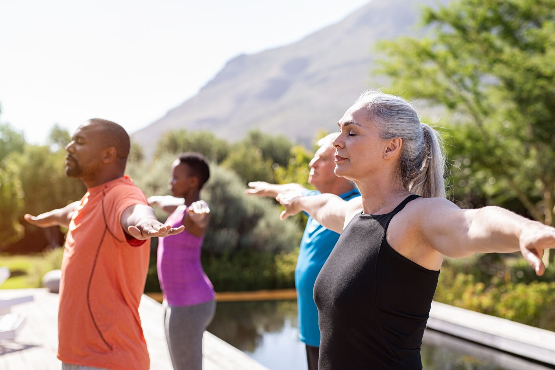 Group of people doing breathing exercises by pool
