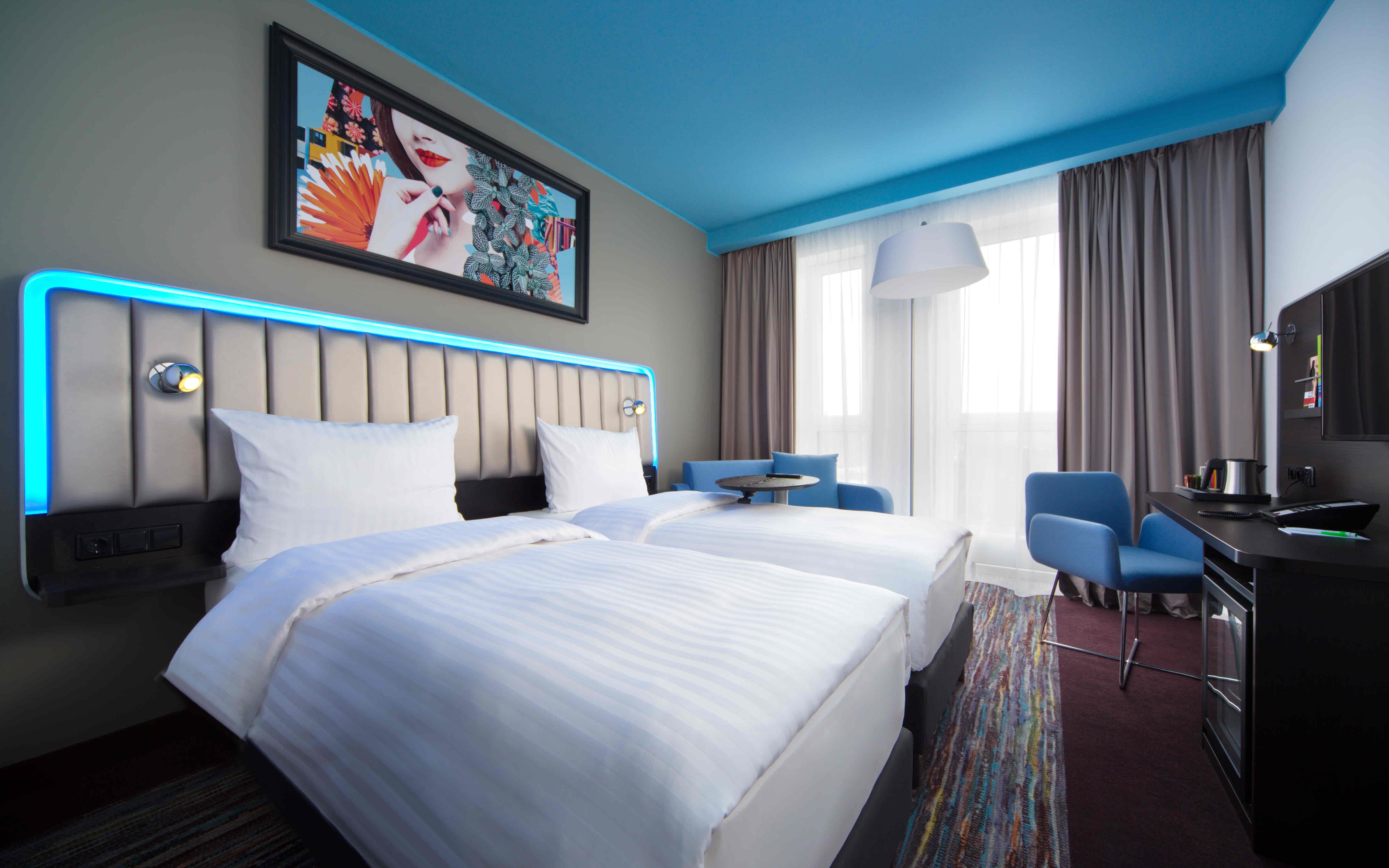 Standard room at Park Inn By Radisson Riga with blue ceiling and blue light headboard