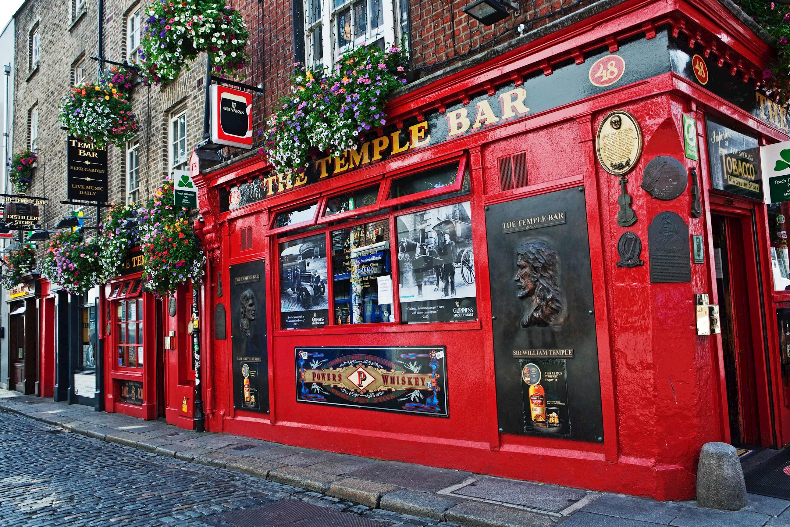 Infamous Temple Bar front featuring ornate details and flower baskets in Dublin, Ireland