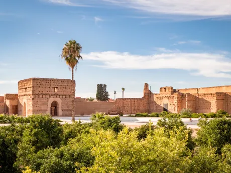 An old palace built of stone with gardens in the foreground in Marrakesh, Morocco.