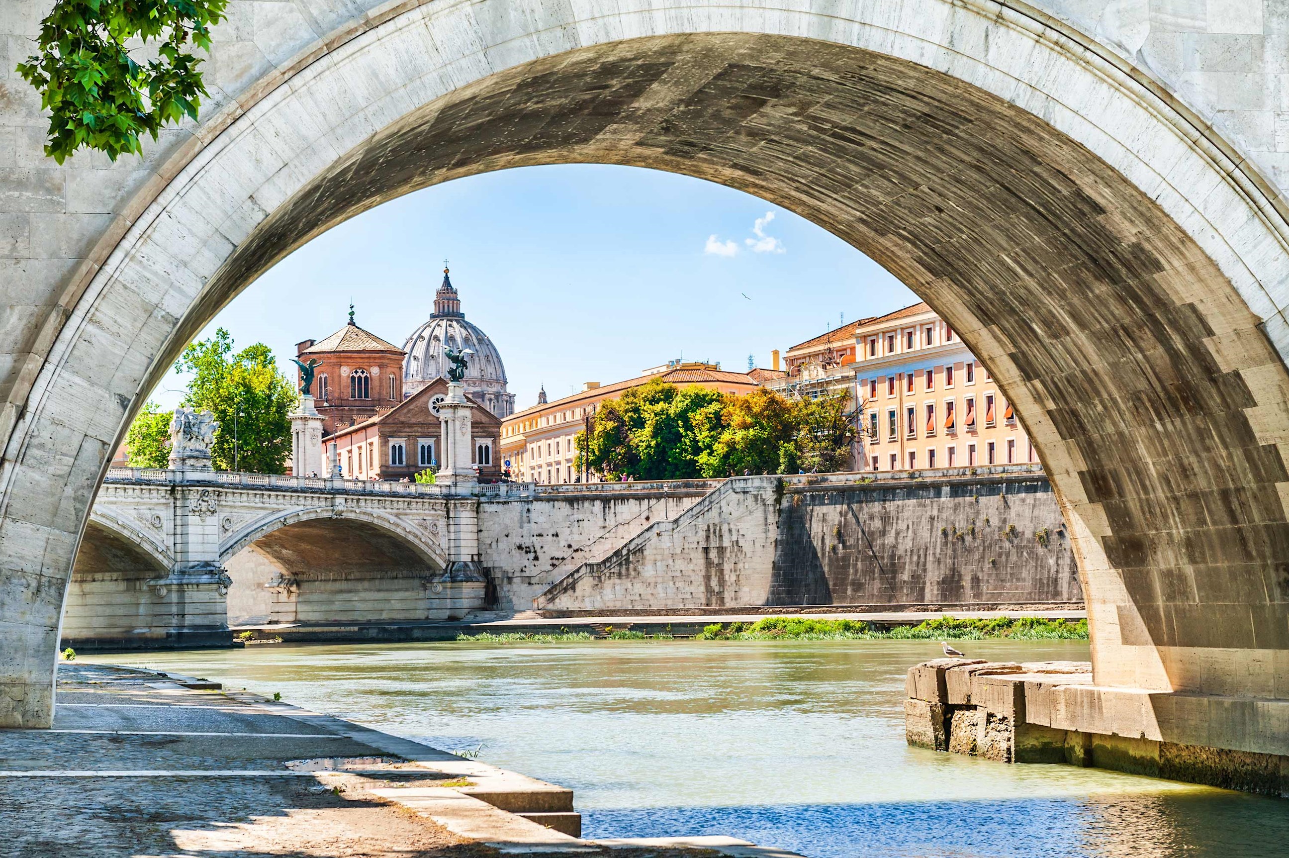 Close view of a stone bridge and riverside buildings in Rome, Italy
