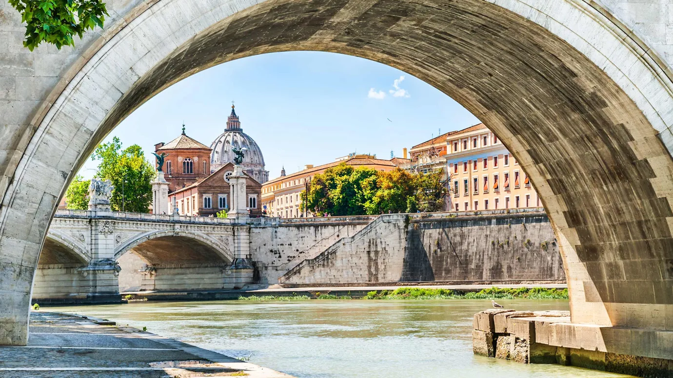 Close view of a stone bridge and riverside buildings in Rome, Italy