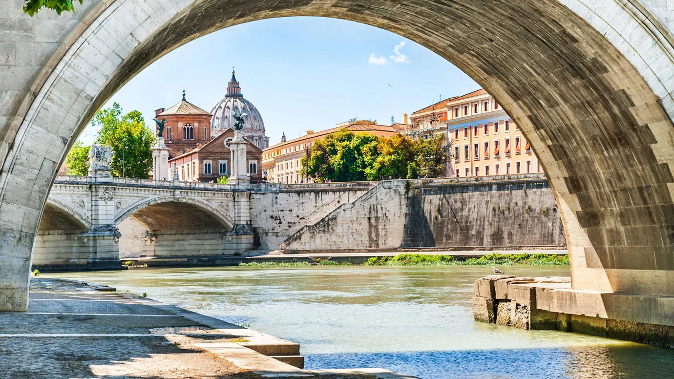 Close view of a stone bridge and riverside buildings in Rome, Italy