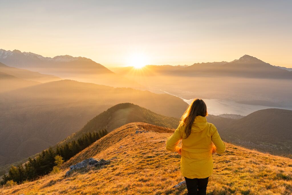 Women in yellow coat looking out to distance at Lake Como