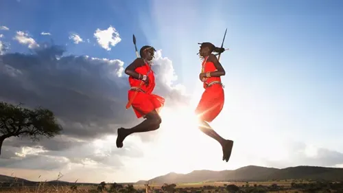 A couple of people that are jumping in the air in Traditional Maasai Village Kenya