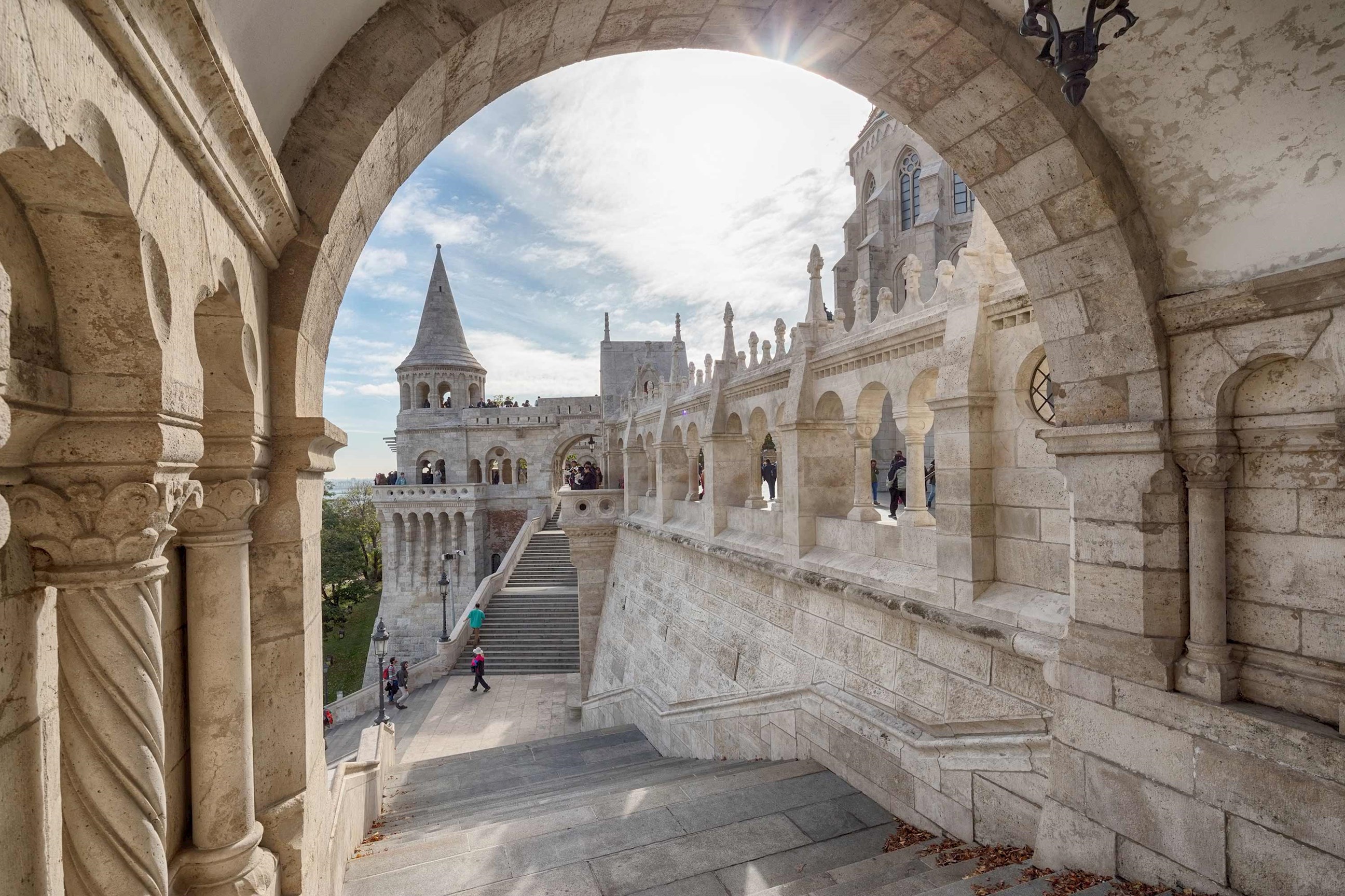 Historic terrace framed by carved arch and elegant stone columns in Budapest, Hungary