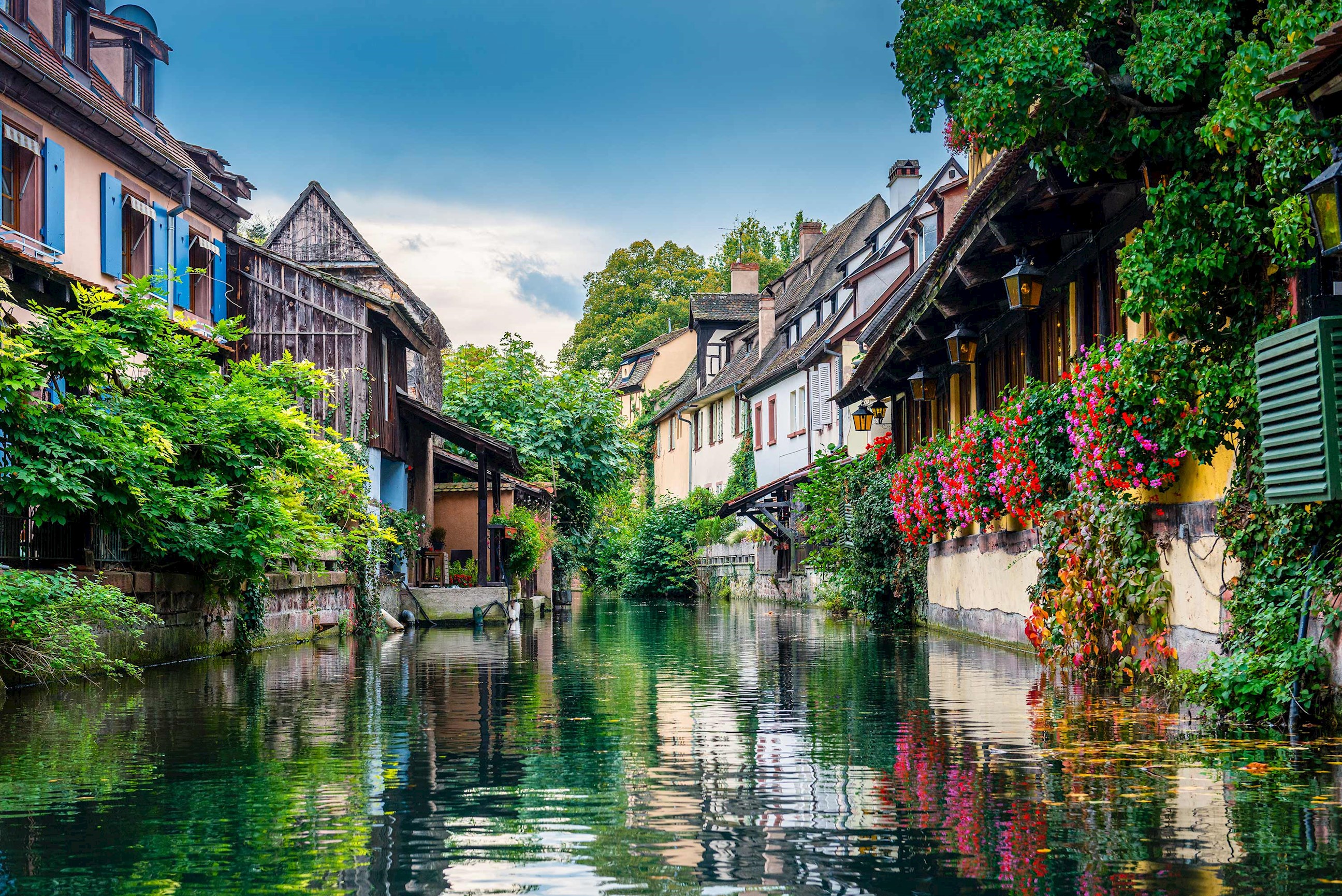 A picturesque canal lined with colourful houses and flowers in Colmar, France