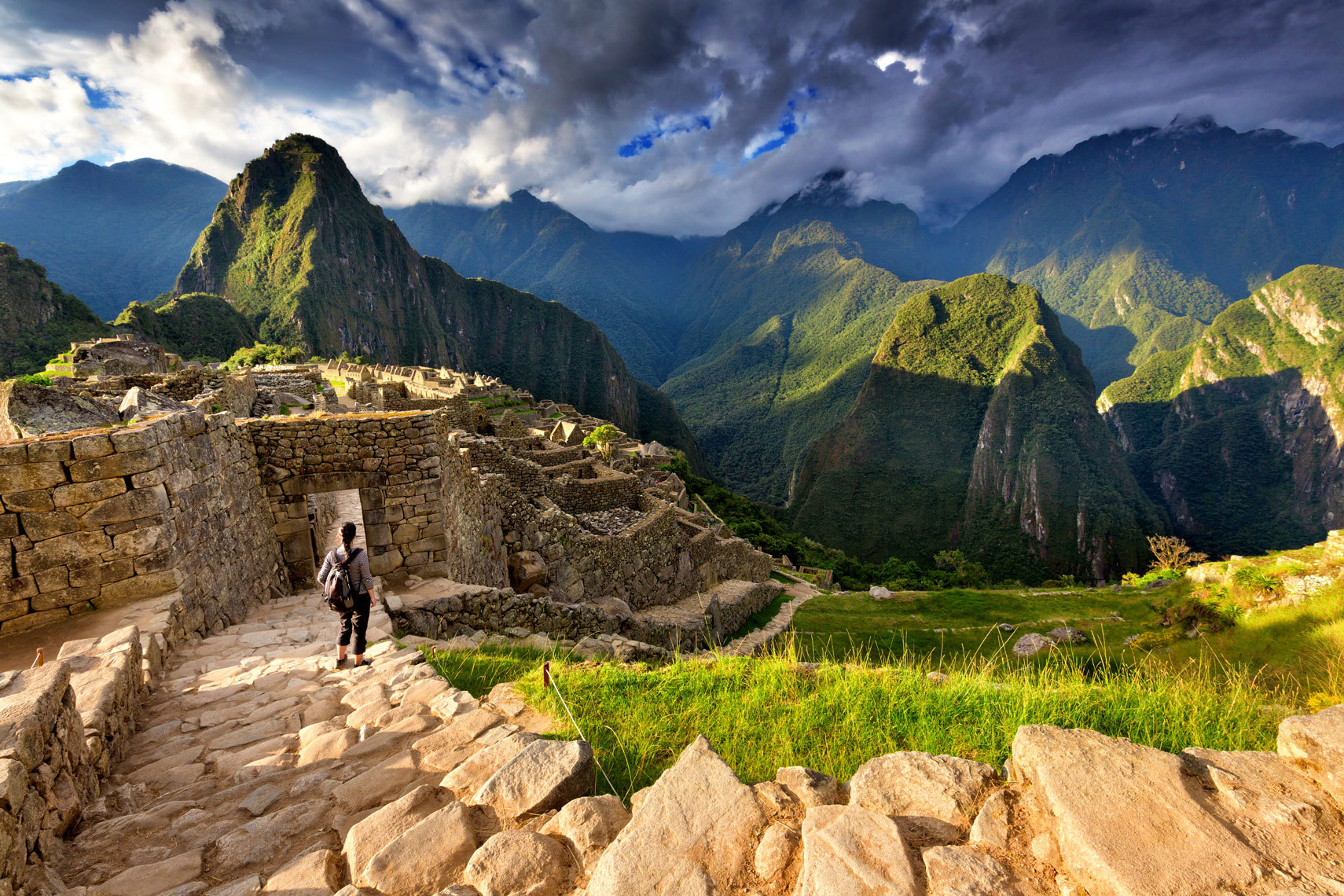 Female tourist descending stairs overlooking Machu Picchu, Peru